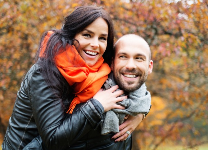 Happy middle-aged couple outdoors on beautiful autumn day